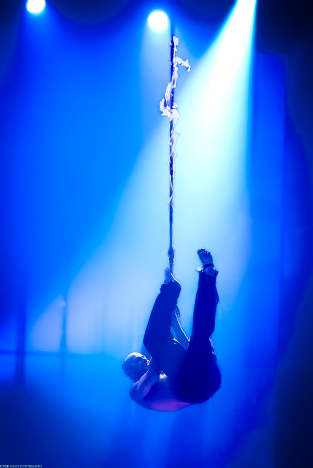Ziutini performing an aerial rope escape under blue stage lights